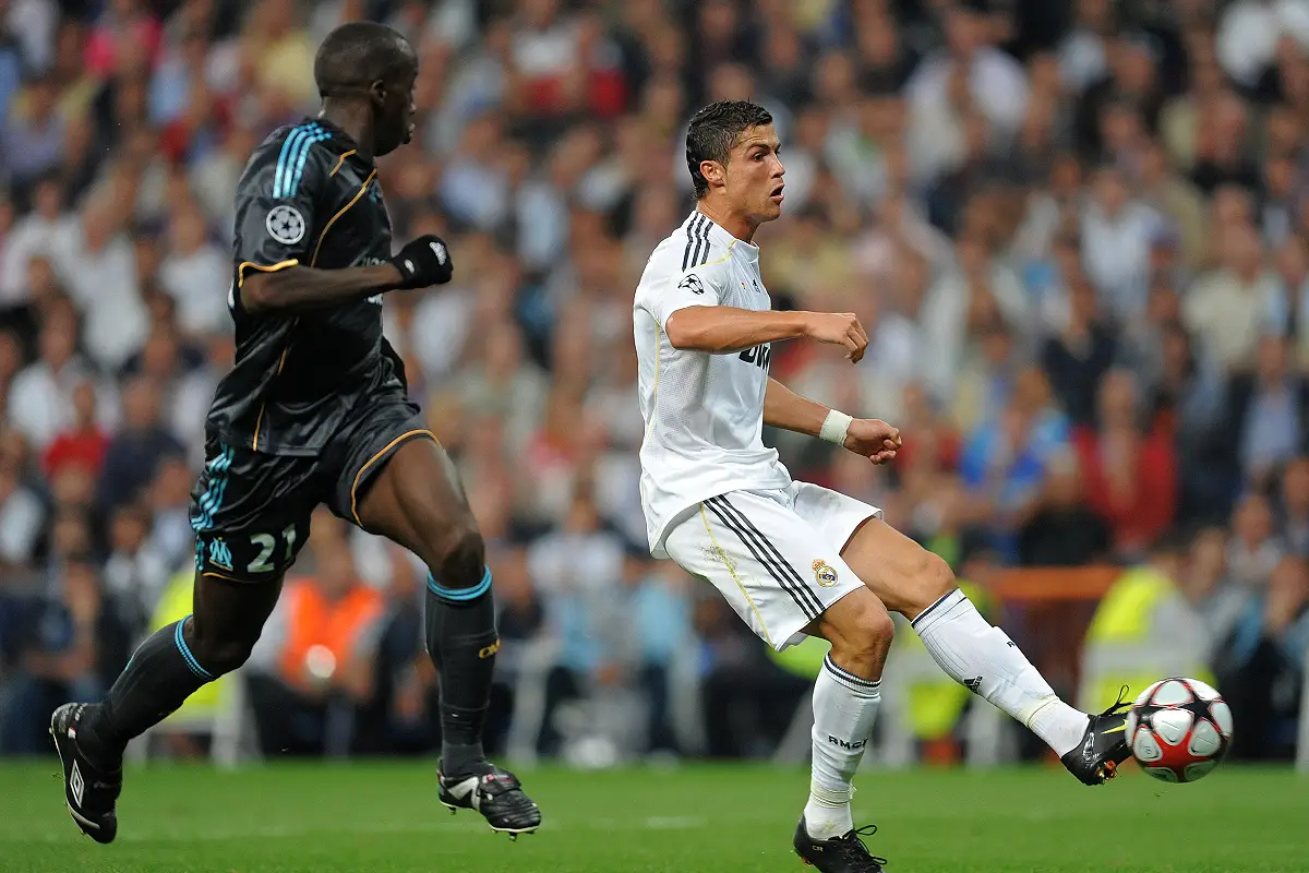 MADRID, SPAIN - SEPTEMBER 30: Cristiano Ronaldo (R) of Real Madrid strikes to score the opening goal past Souleymane Diawara of Marseille during the Champions League group C match between Real Madrid and Marseille at the Estadio Santiago Bernabeu on September 30, 2009 in Madrid, Spain. (Photo by Jasper Juinen/Getty Images)